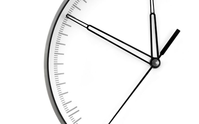 A simple, monochrome clock face with minute and hour hands.