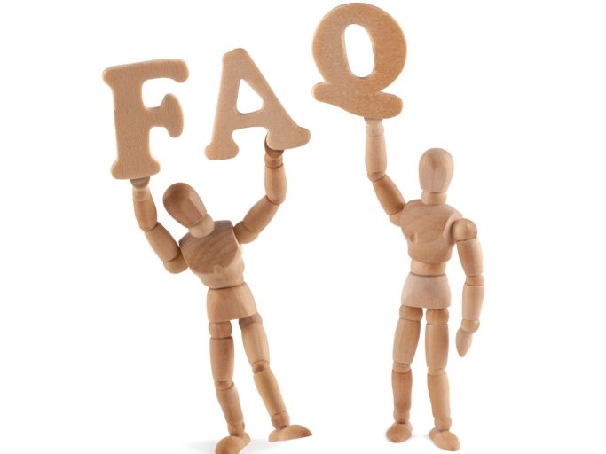 Two wooden figures holding up the letters "F" and "Q".